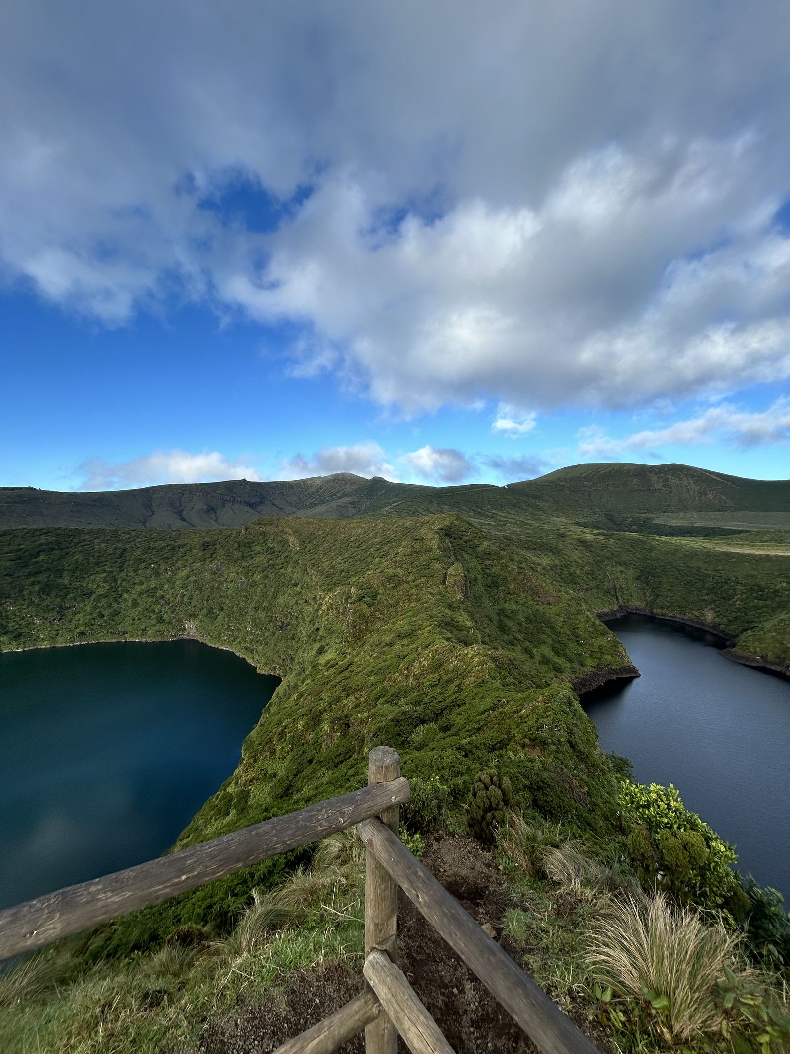 Duas lagoas de cratera separadas por uma crista verde, no planalto central da Ilha das Flores